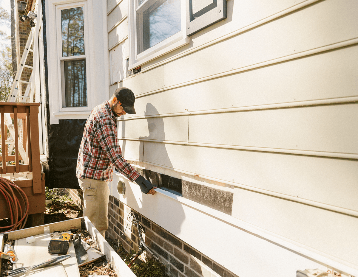Man working on house siding repair